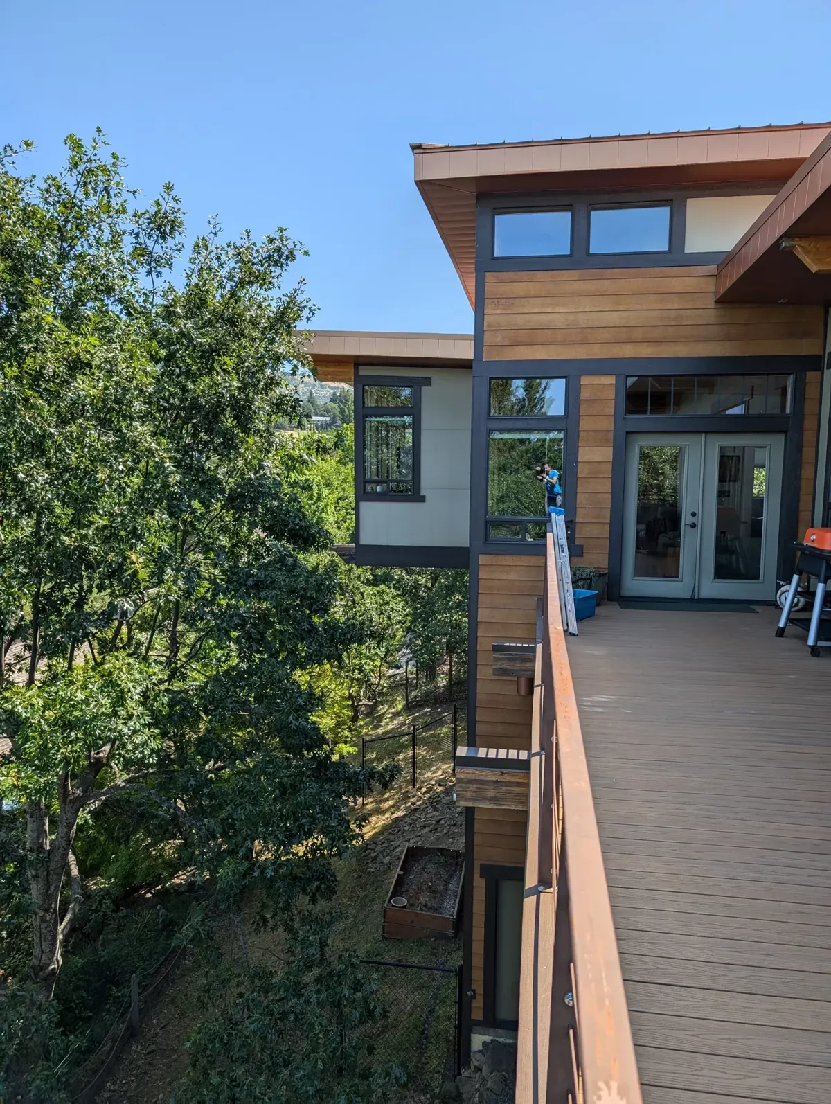 Window cleaning at a home with tall glass and a deck
