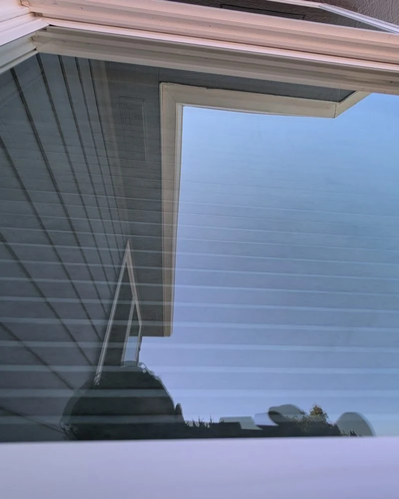 Window glass reflecting a blue sky