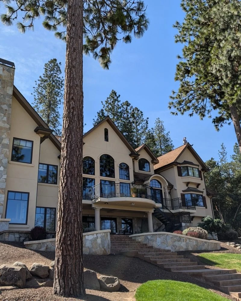 A home with extensive windows surrounded by trees