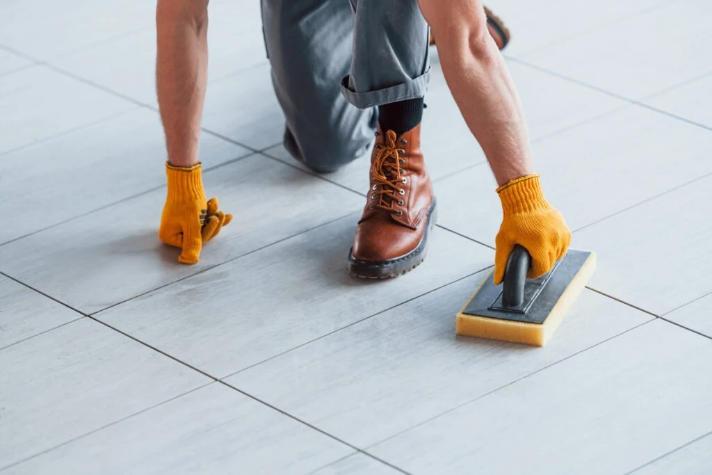 A tiled floor being scrubbed by hand
