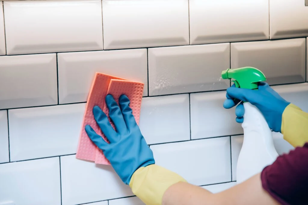 Cleaning tile beside a kitchen backsplash
